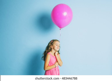 Girl with a pink balloon on a blue background