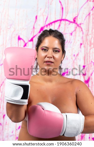 girl with pink boxing gloves fighting breast cancer over a splatter dripping background.