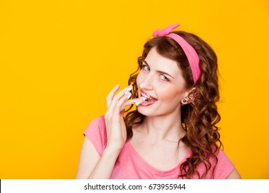 girl in pink dress pinup-style eats cream licks fingers - Shutterstock ID 673955944