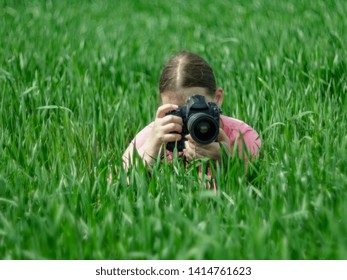 Girl In Pink Jacket Photographs Reflex Camera On Green Wheat Field