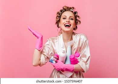 Girl in pink robe laughs and holds detergent on isolated background - Powered by Shutterstock