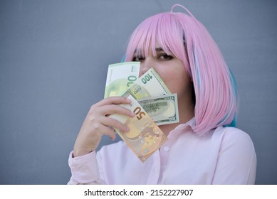 Girl In Pink Shirt And With Pink Color Hair Holding Cash Money Euro And Dollars. Bank Staff Portrait, Anime Hero Cosplay