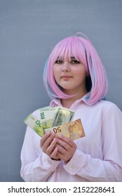 Girl In Pink Shirt And With Pink Color Hair Holding Cash Money Euro And Dollars. Bank Staff Portrait, Anime Hero Cosplay