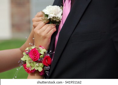 Girl Pins Corsage Onto Prom Date