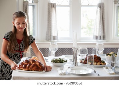 Girl Placing Challah Bread On A Table For Shabbat Meal