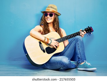 girl play music on acoustic guitar . hipster style portrait of young woman .