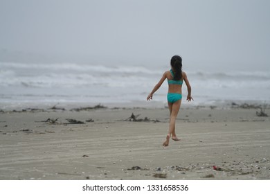 Girl playing along the beach near Galveston, TX