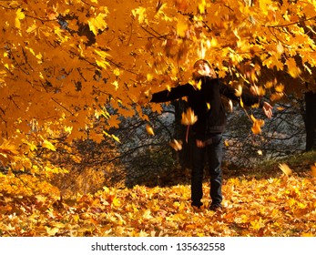 girl playing with autumn leaves