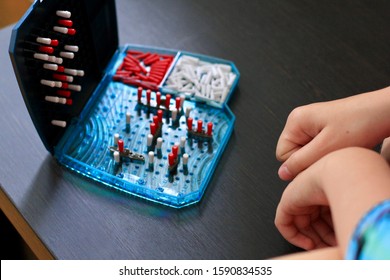 Girl Playing In The Board Game Battleship, Toy War Ships And Submarine. Selective Focus.