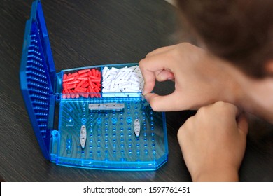 Girl Playing In The Board Game Battleship, Toy War Ships And Submarine. Selective Focus.