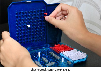 Girl Playing In The Board Game Battleship, Toy War Ships And Submarine. Selective Focus.