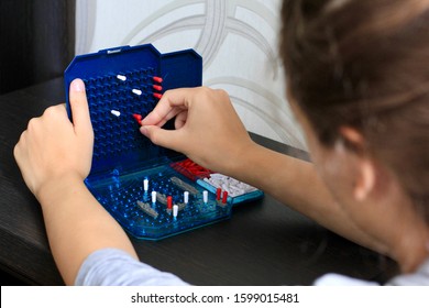 Girl Playing In The Board Game Battleship, Toy War Ships And Submarine. Selective Focus.