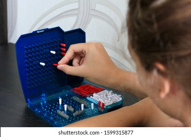 Girl Playing In The Board Game Battleship, Toy War Ships And Submarine. Selective Focus.