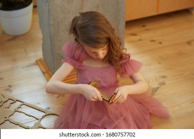 A Girl Playing With Cardboard Toy Dollhouse Furniture.