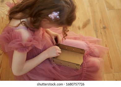 A Girl Playing With Cardboard Toy Dollhouse Furniture.