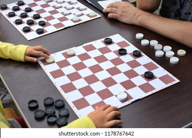 Girl Playing Checkers Outdoor. Checkers Game Board On Wooden Table With Black And White Checkers