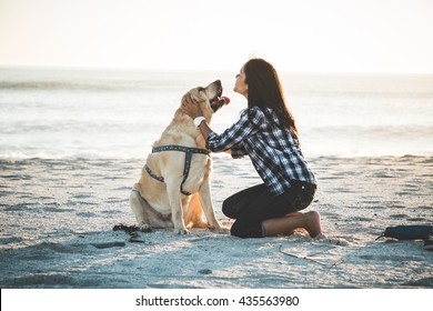 Girl Playing With Dog On Beach