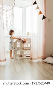 Girl Playing With Doll House In Children Room