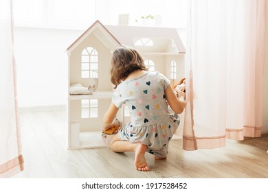 Girl Playing With Doll House In Children Room