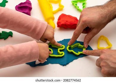 Girl playing dough with her father. father daughter playing game on white background. Making various shapes with dough. Close-up. Father's Day