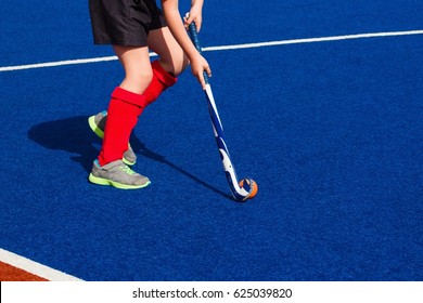 A Girl Playing Field Hockey On Blue 