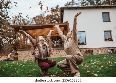 Girl playing with gradmother in garden, throwing leaves in the air. - Powered by Shutterstock