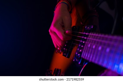 Girl Playing Guitar With Concert Lights And Black Background