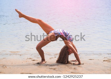Girl playing on the beach.Summer sunny day. Time relax.,schoolgirl making gymnastics on seashore.
