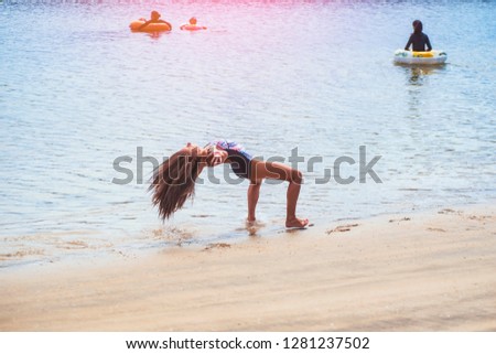 Girl playing on the beach.Summer sunny day. Time relax.,schoolgirl making gymnastics on seashore.