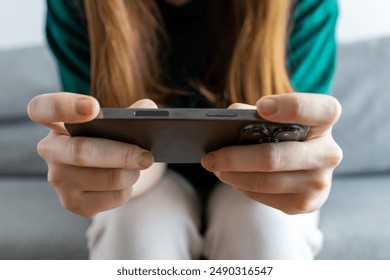 The girl is playing on her phone. The girl is working at the phone. Close-up - Powered by Shutterstock