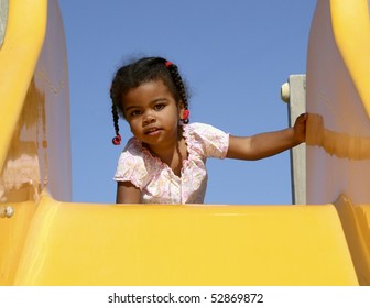 Girl Playing On Slide
A Beautiful African American Child At The Top Of A Playground Slide.
