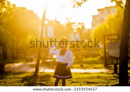 A girl playing with a paper airplane in the park
