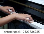 A girl playing piano with note sheet                              