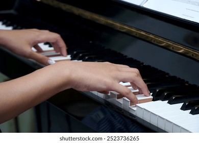 A girl playing piano with note sheet                               - Powered by Shutterstock