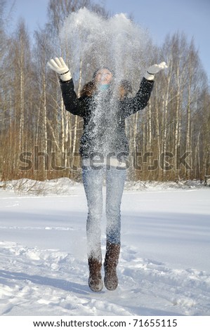 Girl playing with snow in the park in winter