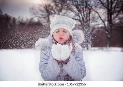 A Girl Playing With Snow In Winter, Making Snow Angel And Eating Icicles 