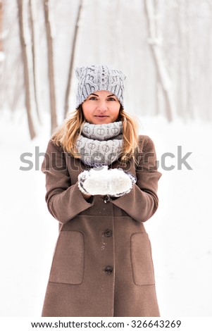 Girl playing with snow in winter park