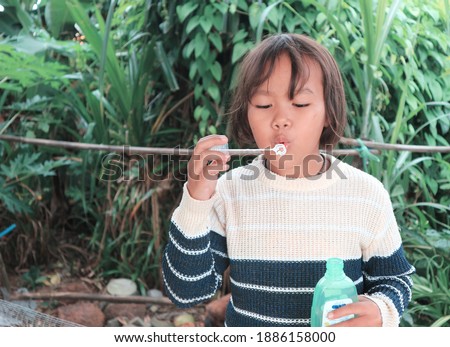 Girl playing with soap bubbles in the garden