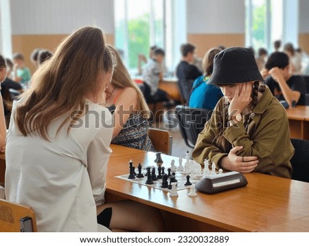 The girl plays chess. Pieces on the chessboard. Chess game, close-up, portrait. Chess tournament, competition