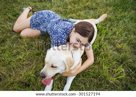 A girl plays with a dog on the grass. Training the dog, the performance of the teams.
