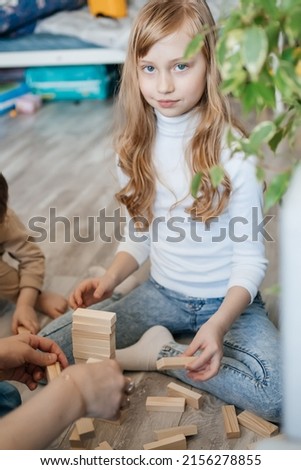 girl plays a game of django with her family on the floor. High quality photo
