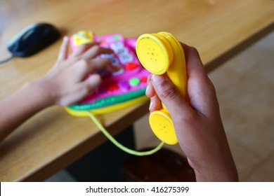 A Girl Plays A Toy Phone.