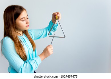 Girl plays a triangle - Powered by Shutterstock