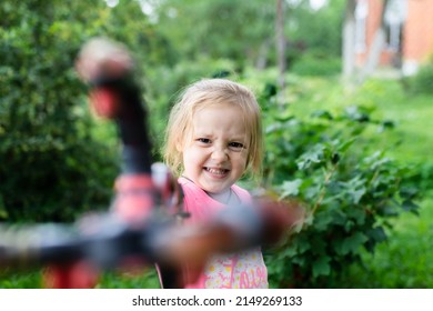 A girl plays in the yard. Front view.