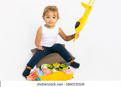 The Girl Plays With A Yellow Plane And Looks At The Camera. Gender Stereotypes.