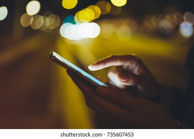 Girl Pointing Finger On Screen Smart Phone On Background Illumination Glow Bokeh Light In Night Atmospheric City, Hipster Using In Hands Mobile Phone, Mockup Lights Street, Online Internet Concept