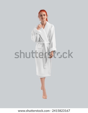 Girl posing in full length in a white plush robe - mockup of home clothes for design, branding, advertising. Isolated bathrobe template on the background, front, presentation for commercial purposes