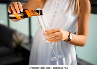 Girl pouring champagne into glass
