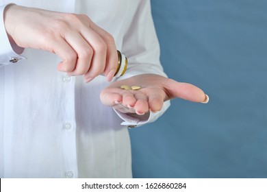 Girl pours pills on the palm, closeup