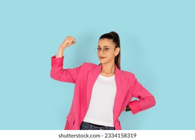 Girl power, young strong sporty fit employee showing biceps muscles on hand. Wearing classic formal pink suite and work glasses. Business woman, lawyer, secretary, teacher, professional. Copy space.